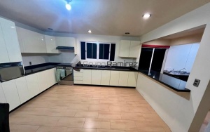 Cocina en alto brillo beige con cubierta negro san gabriel.