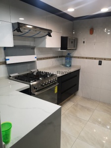 Cocina integral bicolor negro con blanco cubierta de cuarzo calacatta con grapa