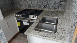 Cocina integral en melamina Laricina con cubierta de granito Blanco dallas