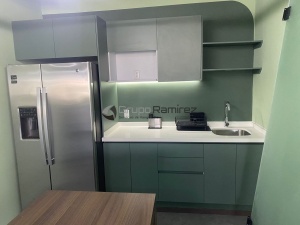 Cocina en acabado super mate verde con cubierta de cuarzo blanco
