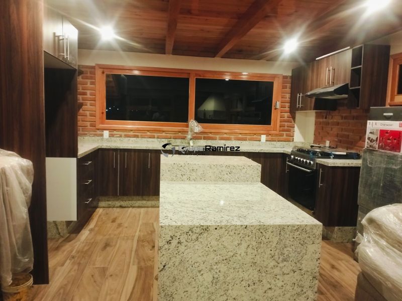 Cocina integral acabados en melamina color café, cubierta de granito natural blanco Dallas estilo contemporáneo con jaladeras cubiertas en tono claro